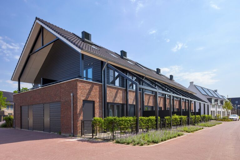 Moderne rijwoningen met houten gevelbekleding, zonnepanelen en groene erfafscheidingen
