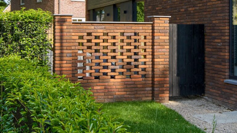 Eigentijdse woning waarin warme baksteen, een markante kap en donkere houten details samenkomen in een krachtig en sfeervol ontwerp.