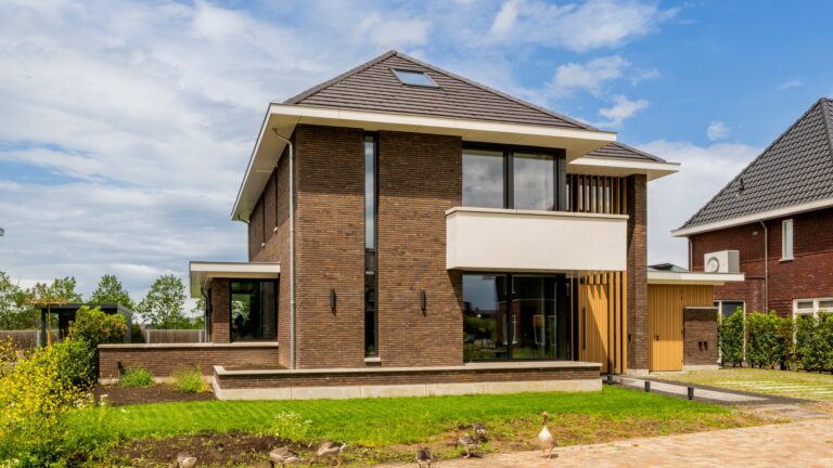 Voor- en zijgevel van eigentijdse woning in Nijmegen met baksteen en houten accenten