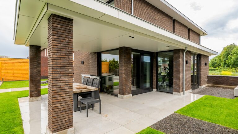 Achtergevel eigentijdse woning Nijmegen met grote glazen puien en overdekt terras